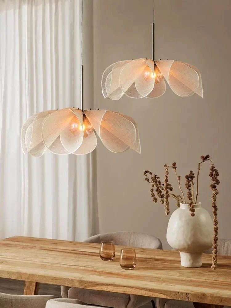 Pair of modern bubble glass chandeliers in nordic style, suspended above a wooden dining table with minimalist decor and soft lighting.