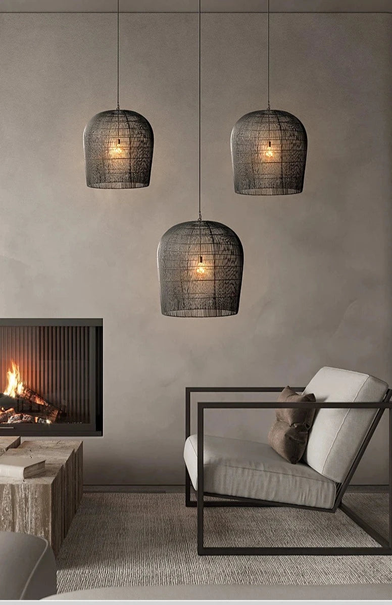 Three black LUXELY industrial rattan pendant lamps illuminating a cozy living room with fireplace and modern decor.
