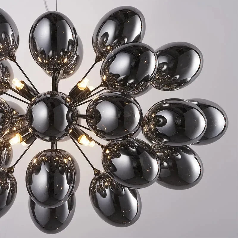 Modern glass chandelier with grape-like cluster of glossy black bulbs, designed for contemporary home lighting in living or dining areas.