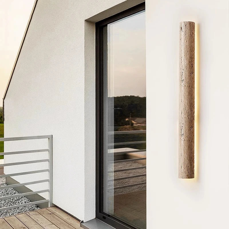 Tall IP65 travertine wall light mounted on balcony wall, providing stylish and weatherproof outdoor lighting solution.