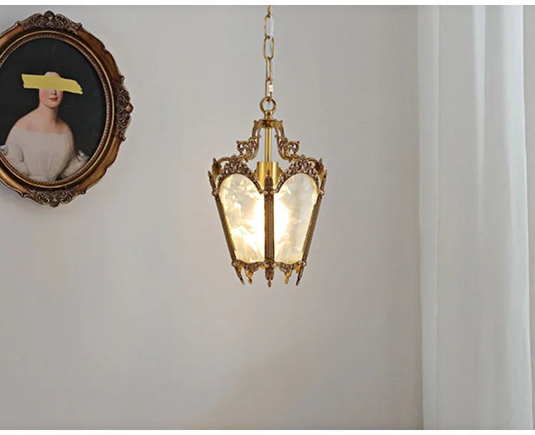 French retro chandelier with LED light hanging in a white-walled room. Copper and glass design suits classic interiors.