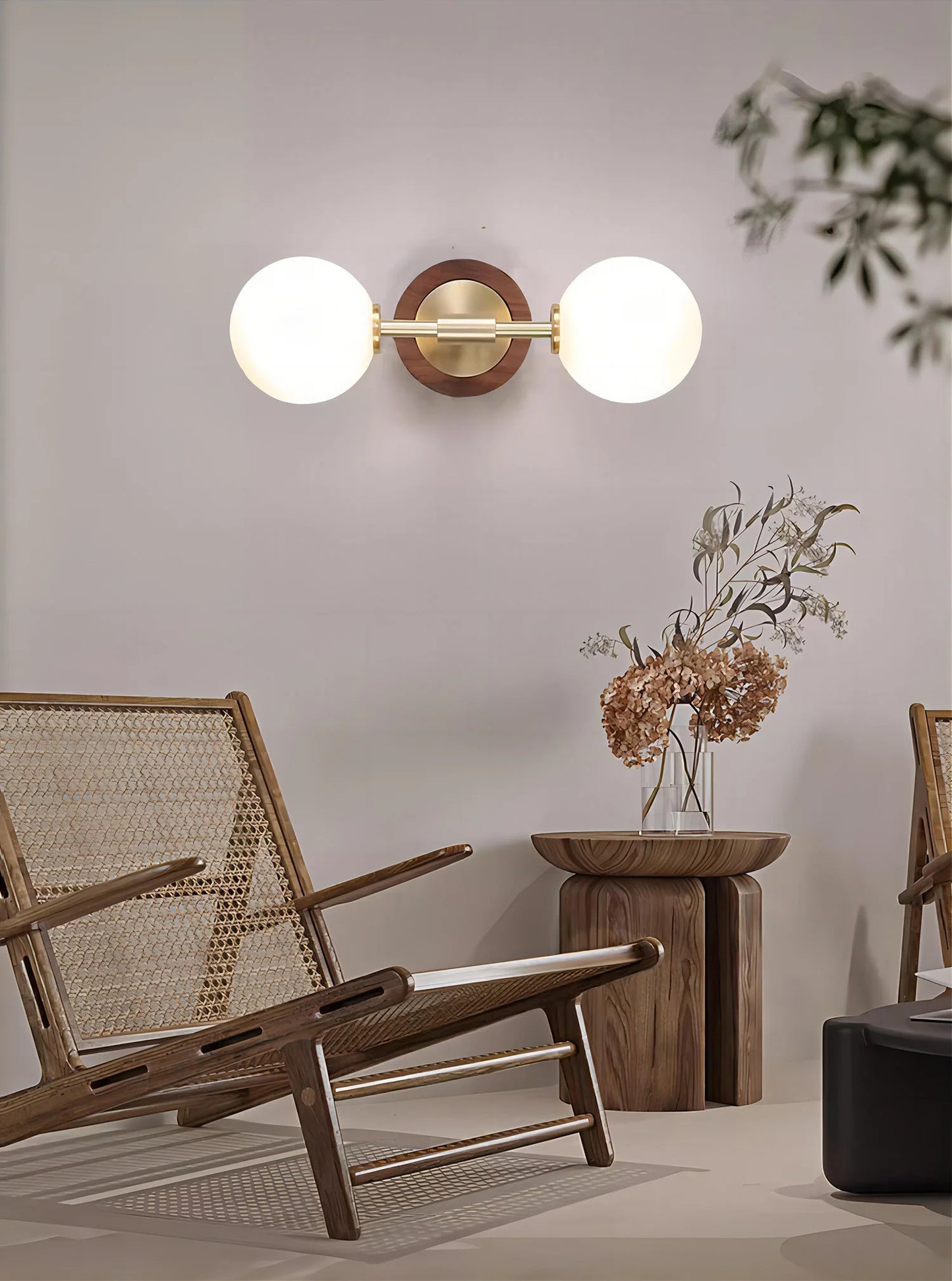 Horizontal modern brass wall sconce with dual globes, styled in a Nordic-inspired living space with natural wood accents.