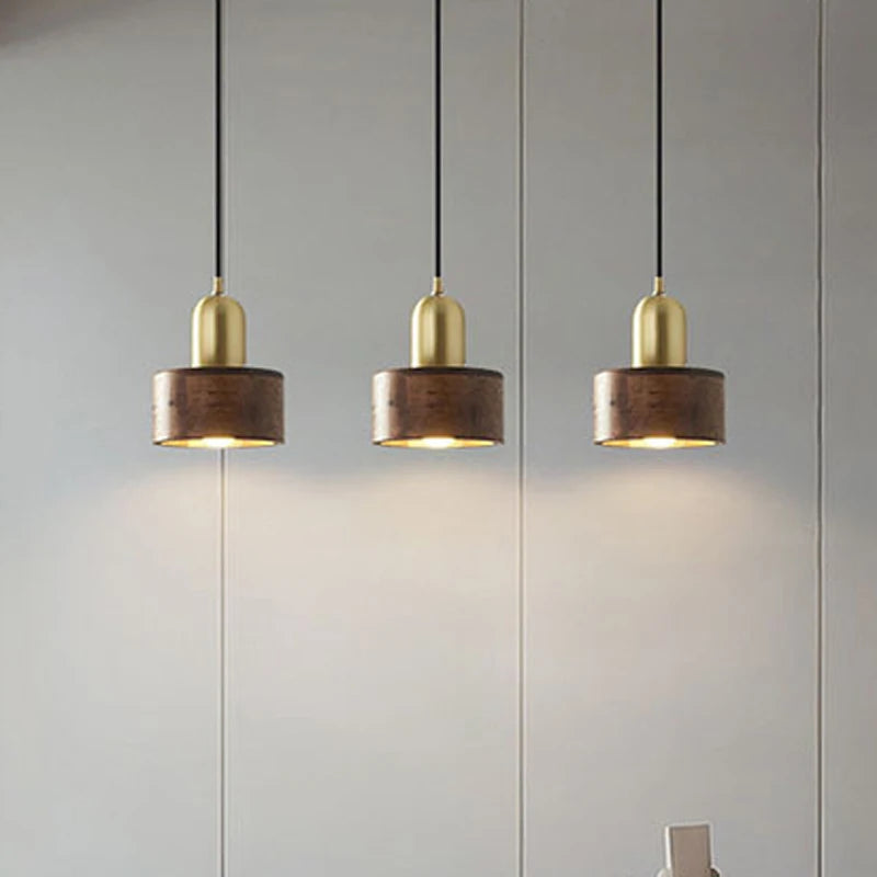 Set of three LUXELY walnut wood pendant lights with brass tops, perfect for kitchen islands or dining room lighting.