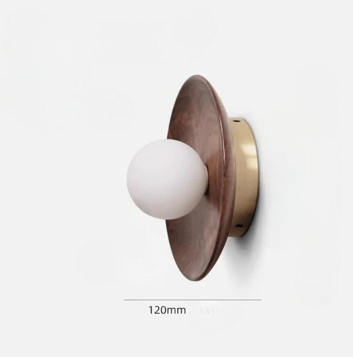 Compact walnut wood wall lamp with 120mm diameter and brass base, designed for modern minimalist interiors.