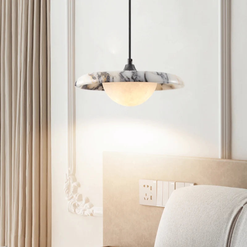 Black round Matte Marble Pendant Lamp installed above a bed, blending with classic bedroom decor and providing warm LED illumination.