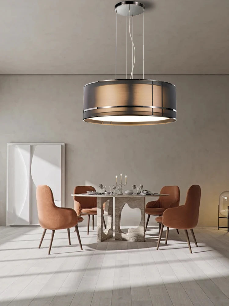 Stylish Italian designer chandelier lighting a chic dining area with peach velvet chairs and a sculptural stone table.