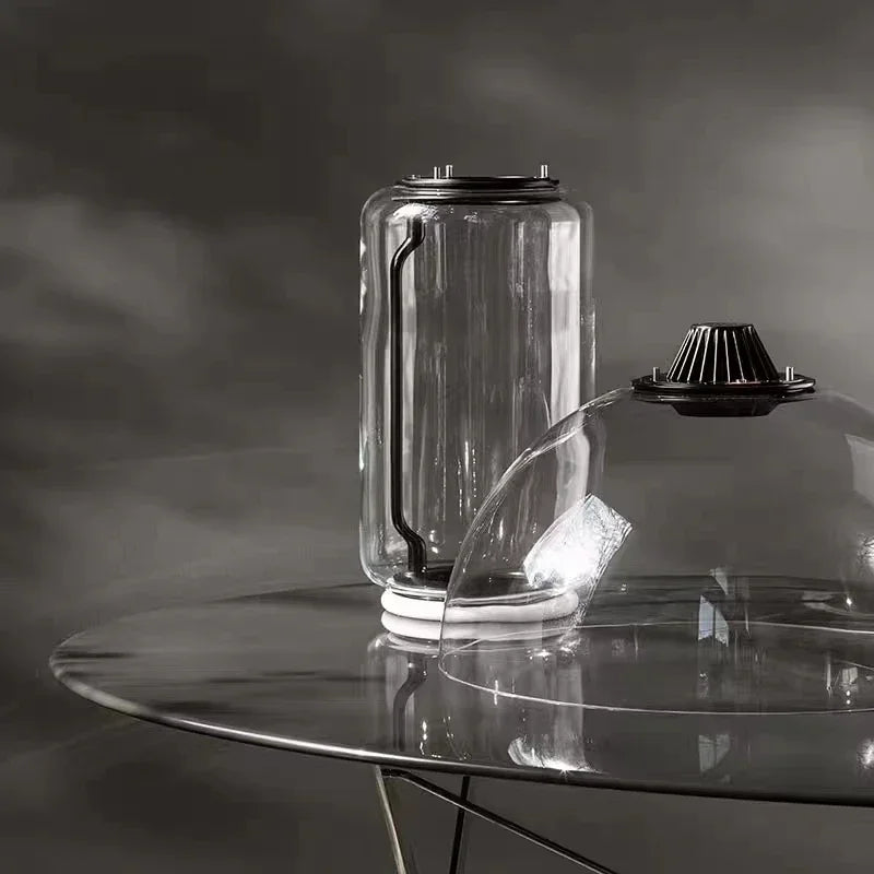 Close-up of Italian minimalist glass floor lamp – modern nordic design with transparent cylindrical glass and LED base lighting.