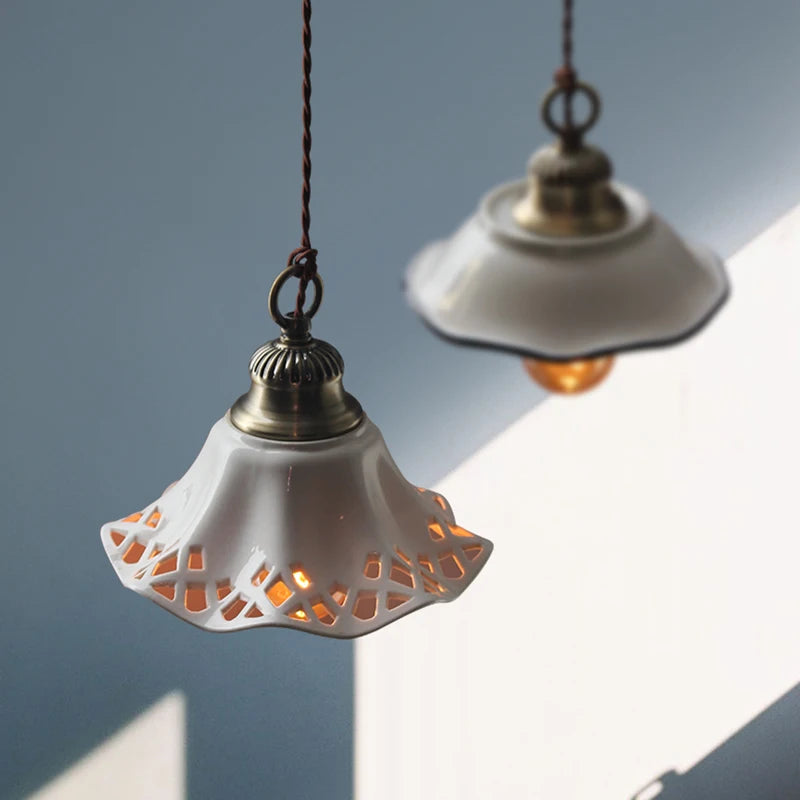 White ceramic pendant lights with cut-out floral patterns and warm LED glow, ideal for cozy kitchen or bedroom ambiance.