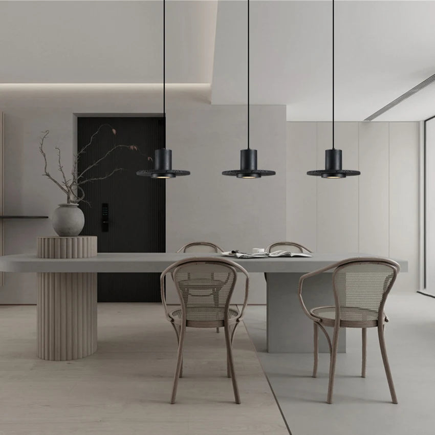 Three LUXELY industrial pendant lights over a contemporary dining table, perfect for restaurant or home dining room ambiance.