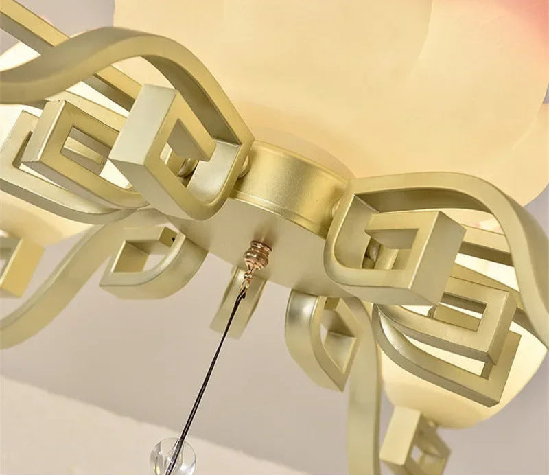 Base detail of lotus flower LED pendant light with gold geometric arms, highlighting craftsmanship and vintage design.