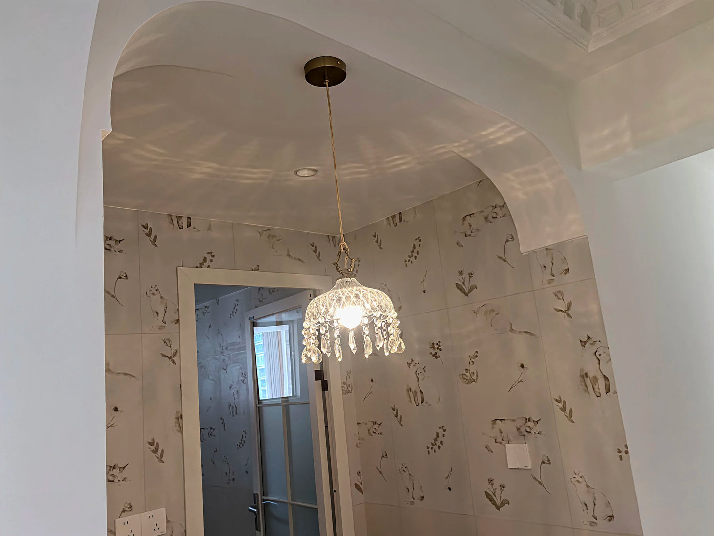 French Vintage Crystal Chandelier - Copper Hanging Lamp installed in arched hallway, casting decorative light reflections.