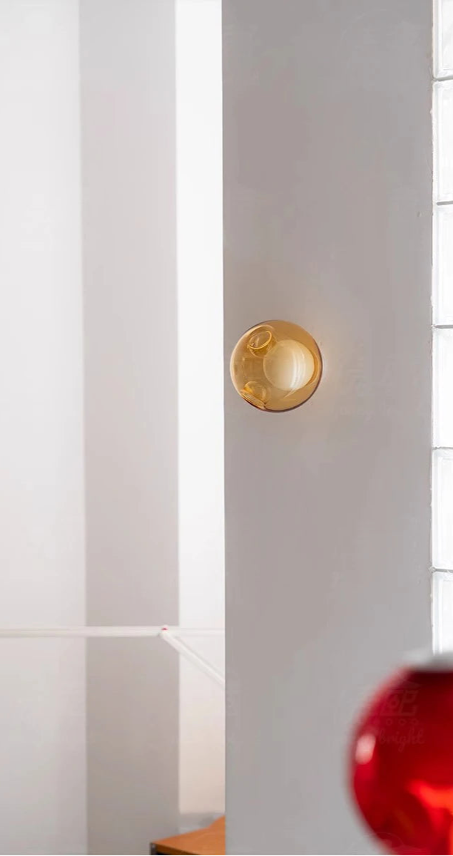 Amber Italian designer glass wall sconce on a white wall, ideal for soft LED lighting in contemporary bedroom or café settings.
