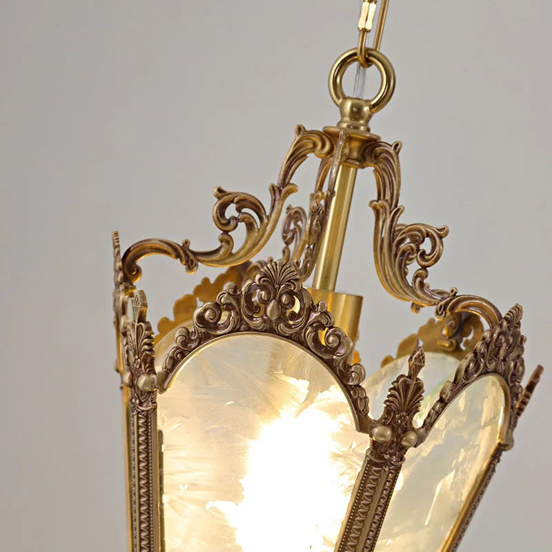 Close-up of ornate copper detailing on French retro glass chandelier. Durable and stylish lighting fixture for vintage-themed interiors.