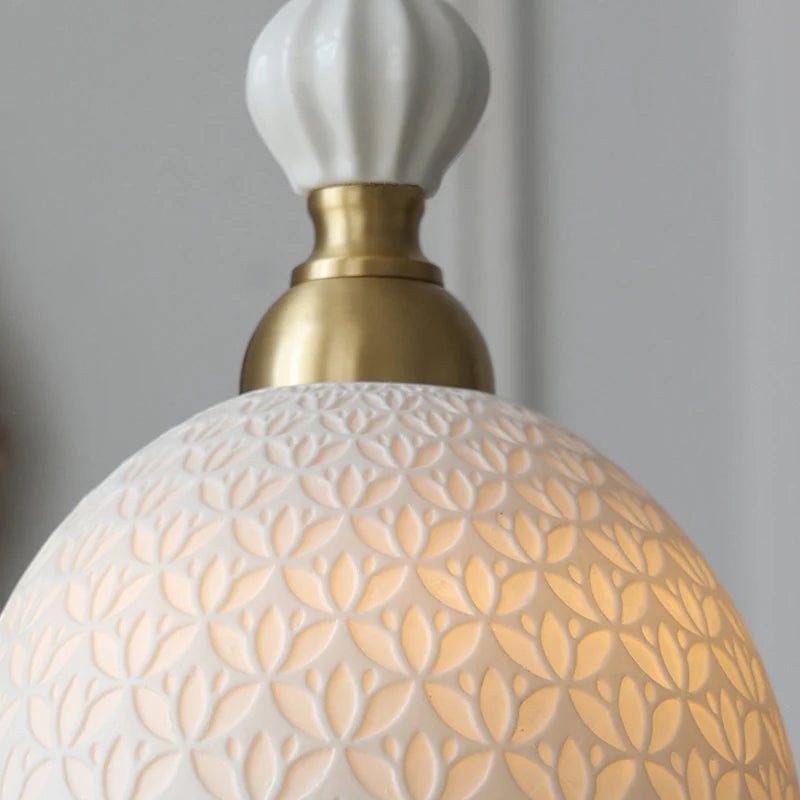 Close-up of French Modern Cream Chandelier showing intricate floral embossing and brass detailing for refined home lighting.