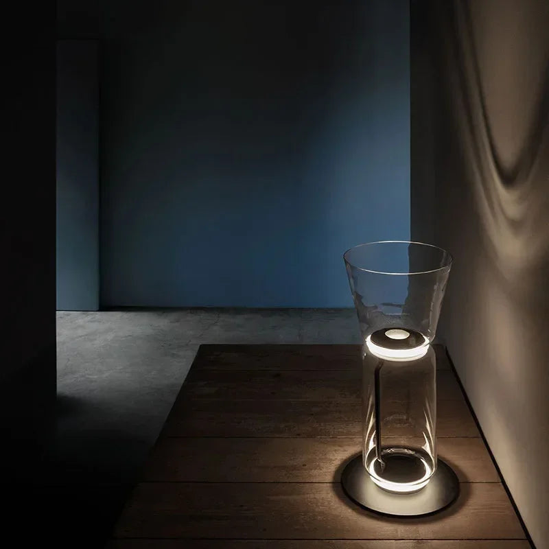 Short Italian glass floor lamp – modern minimalist nordic design with LED lighting and transparent glass, casting ambient wall light.