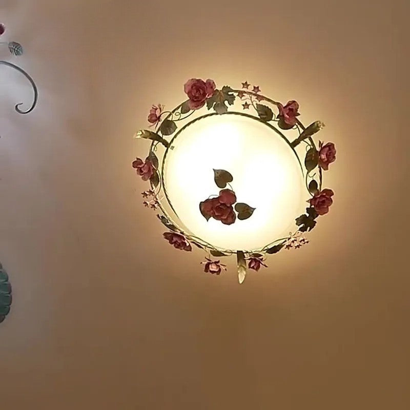 Dimmable romantic pink chandelier with glowing light and rose details. French rose design complements cozy bedroom lighting.