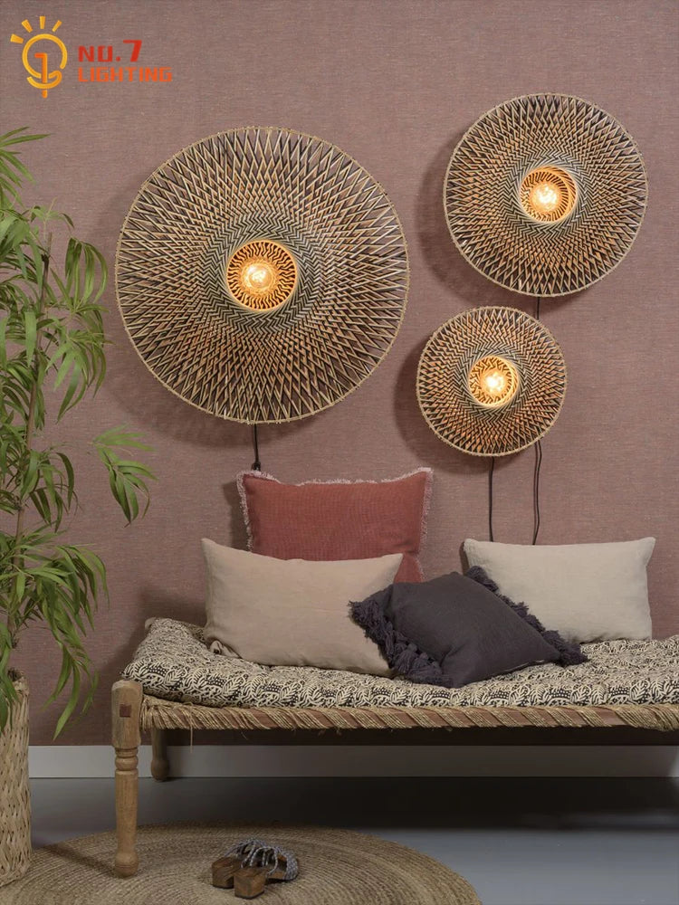 Set of three Wabi-sabi bamboo wood wall lamps on a pink wall above a woven bench, ideal for cozy boho-style interiors.