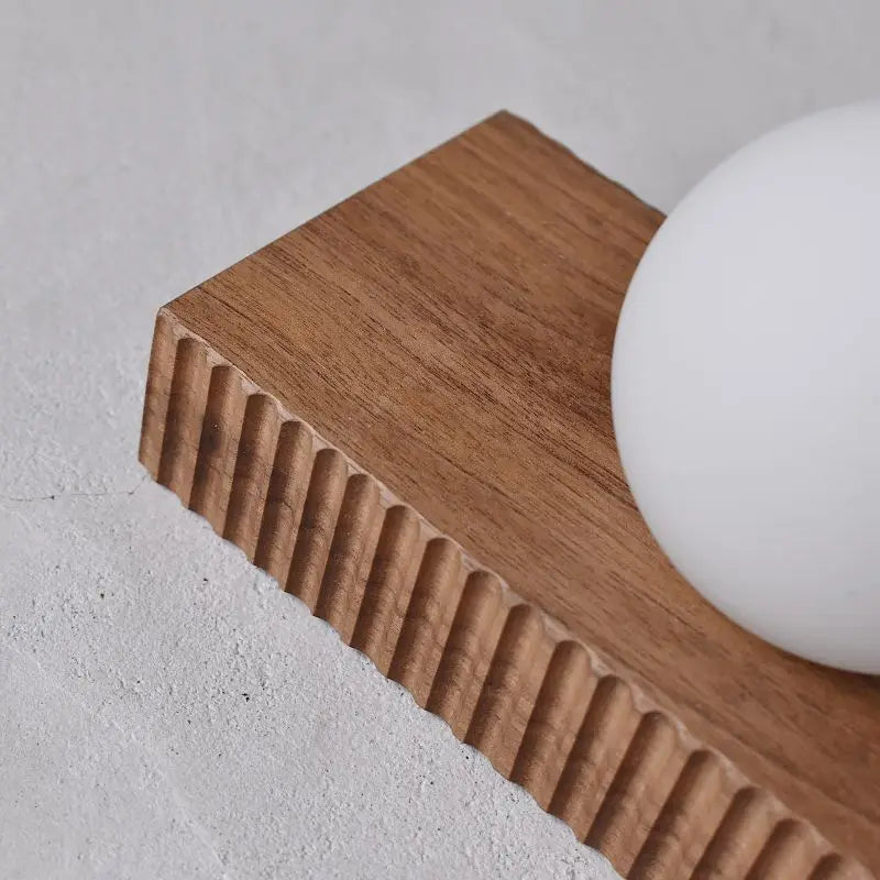 Detailed view of walnut wood grain and ribbed texture on the LUXELY wall lamp, designed for modern home lighting.