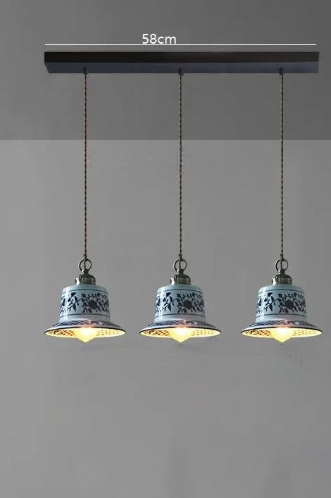 Three bell-shaped ceramic pendant lights with blue floral patterns on a 58cm bar, perfect for dining or kitchen lighting.