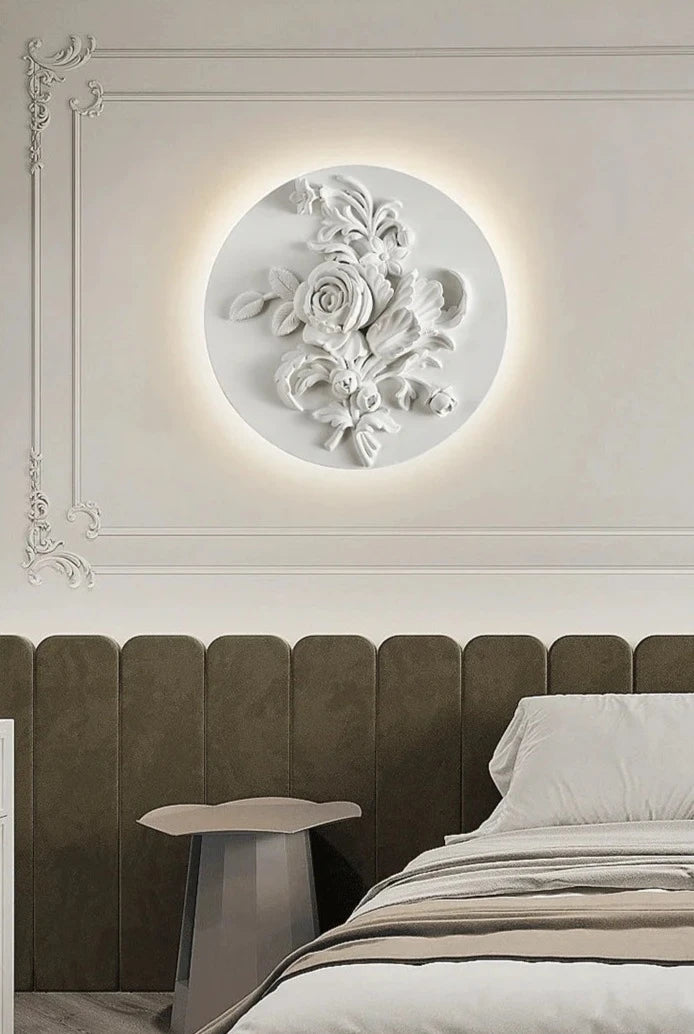 Round floral French vintage sconce mounted above bed, casting ambient LED light for luxurious bedroom wall lighting.