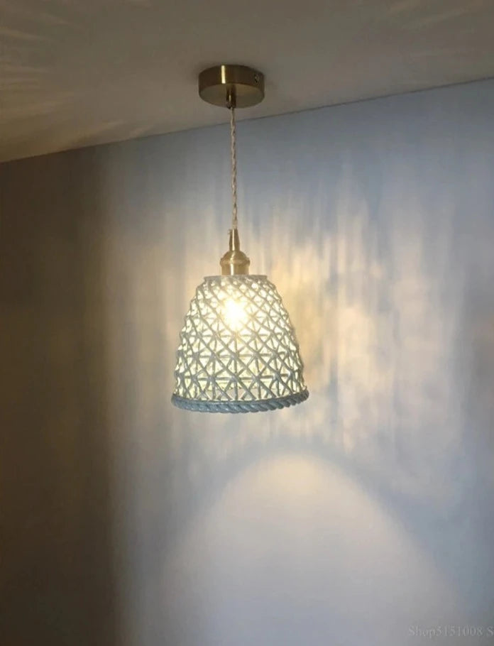 Blue LUXELY ceramic Japanese pendant light mounted on ceiling, casting soft shadows on wall for ambient room lighting.