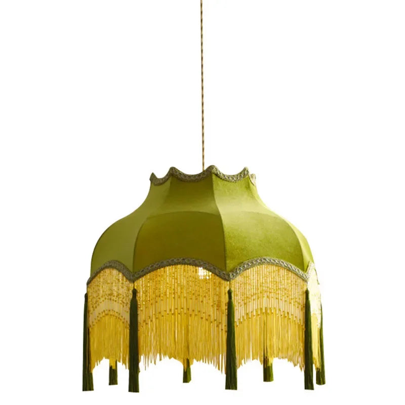 Close-up of green velvet pendant chandelier with scalloped edges and gold fringe, showcasing vintage craftsmanship.