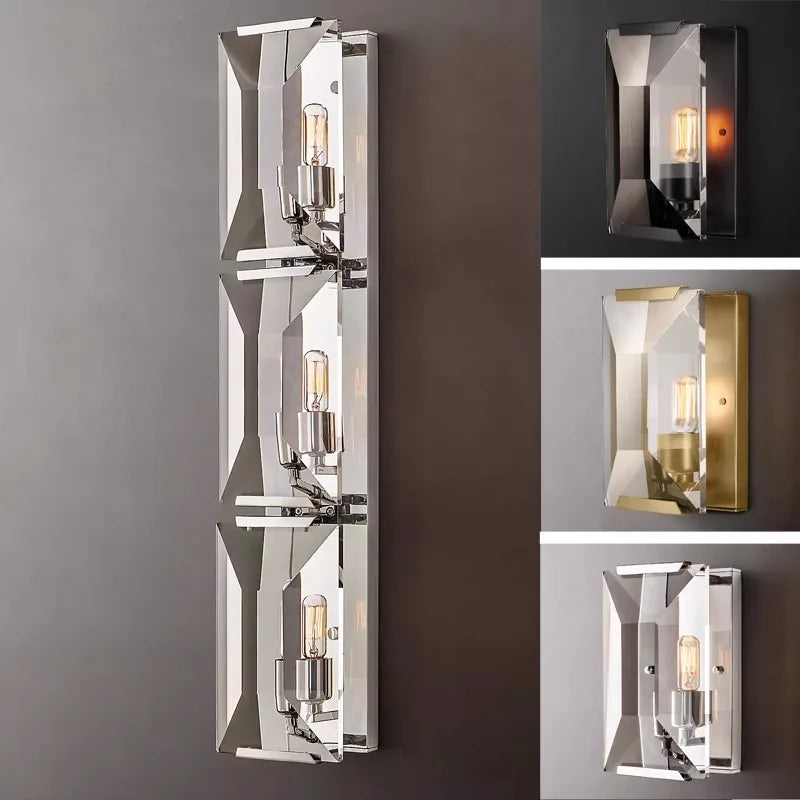 Crystal and stainless steel LED wall sconces in various finishes, showcasing modern faceted design for upscale interiors.