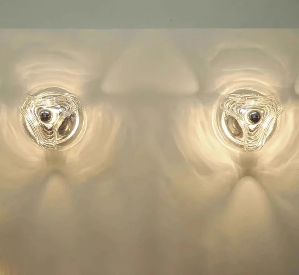 Pair of designer LED glass wall lamps casting ambient light patterns, suitable for modern interiors and commercial spaces.