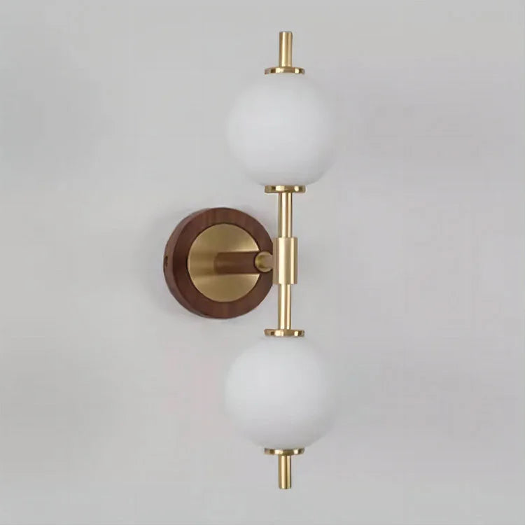 Unlit LUXELY brass wall sconce with frosted globes and wood base, showcasing minimalist design for modern homes.