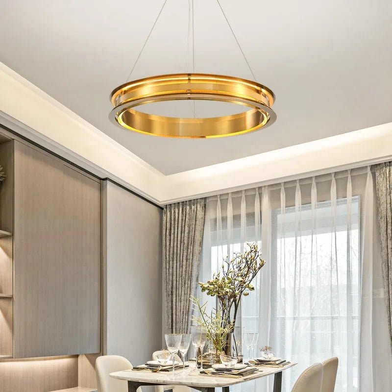Italian minimalist gold LED chandelier above a dining table, enhancing contemporary home interiors with warm lighting.