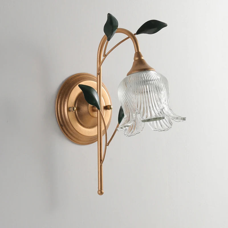 Unlit French Wall Sconce Light showcasing clear ribbed glass flower shade, golden branch, and green leaves for vintage wall decor.
