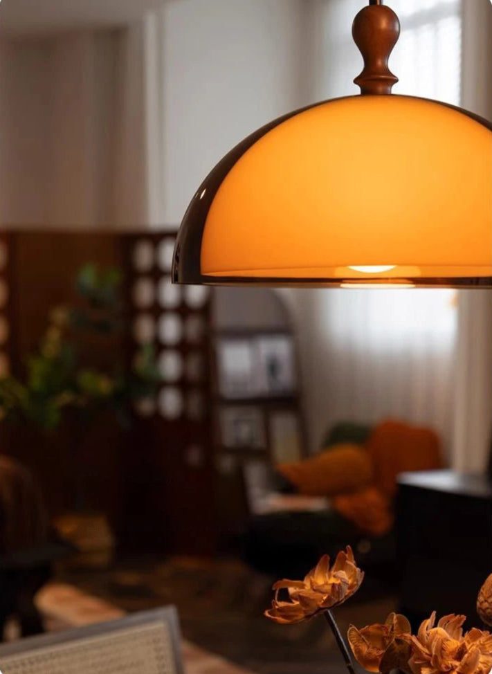 Close-up of LED Pendant Light casting warm light in a modern living space, highlighting its sleek amber dome design.