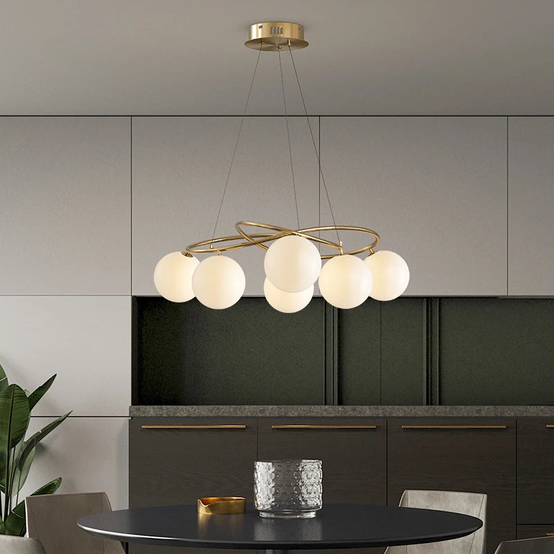Cream finish LED Chandelier with gold frame and spherical lights, enhancing a minimalist kitchen with warm, ambient lighting.