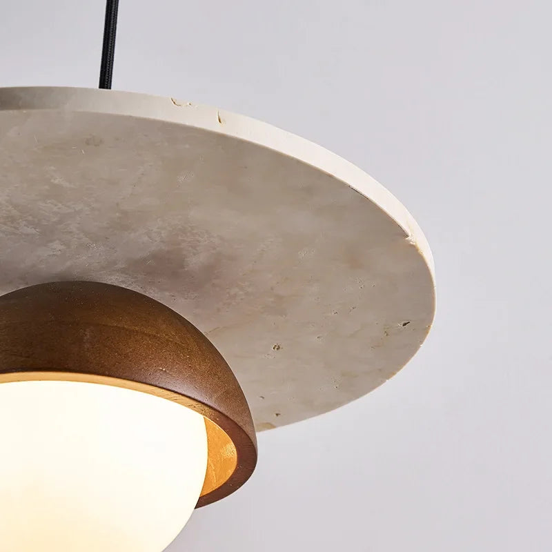 Close-up of walnut wood and stone pendant showing natural stone texture and LED bulb glow.