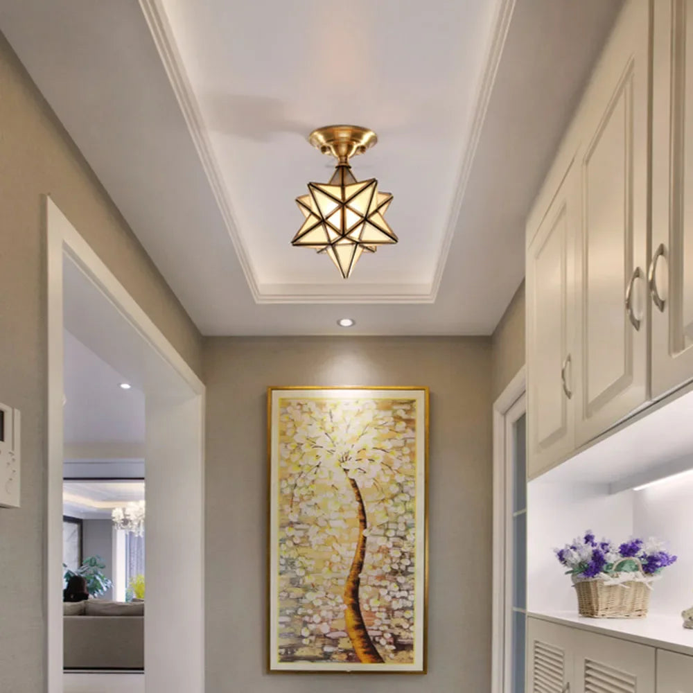Modern copper flush mount ceiling light installed in hallway, enhancing home decor with elegant geometric glass lighting.