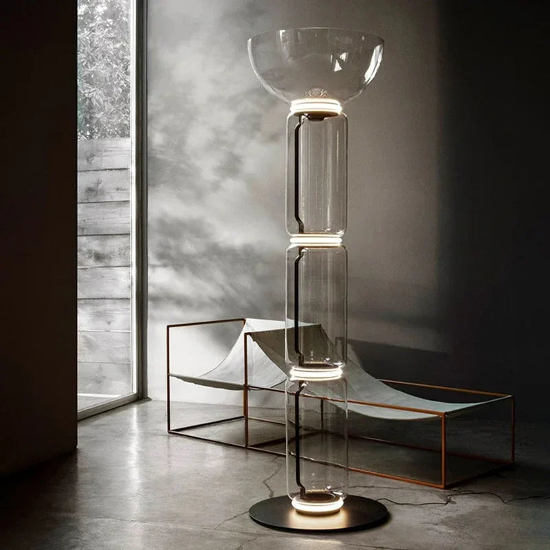 Italian minimalist glass floor lamp – nordic design with clear stacked glass and LED rings, placed in a modern sunlit room.