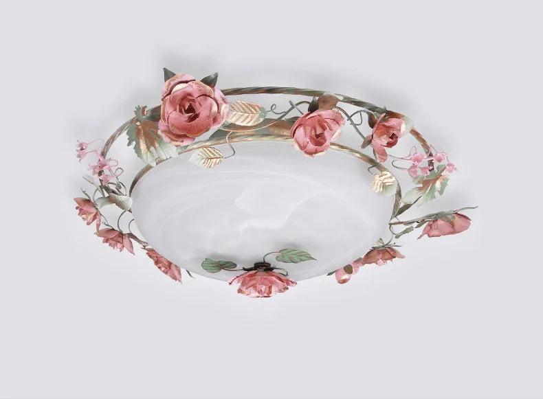 Close-up of French rose romantic chandelier with detailed pink flowers. Elegant ceiling light fixture for bedrooms or living rooms.