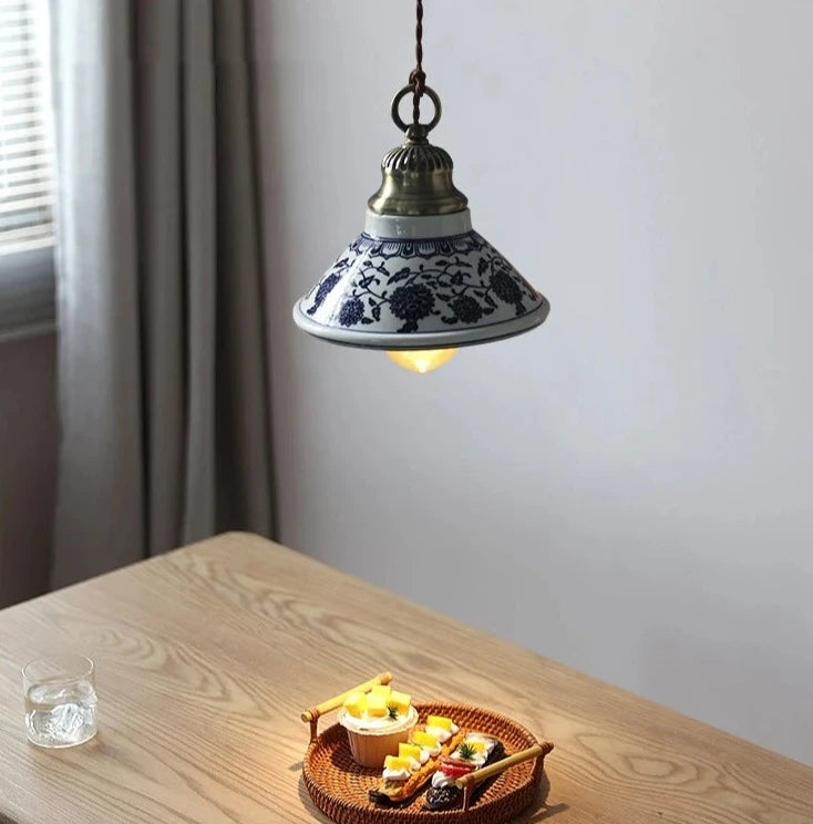 Single cone-shaped ceramic pendant light with blue floral design, ideal for cozy dining room or kitchen ambiance.