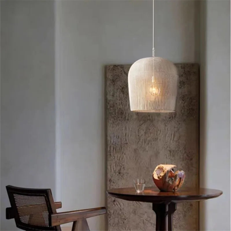 White LUXELY handmade rattan pendant light above a small round table, perfect for cozy dining or reading corners.