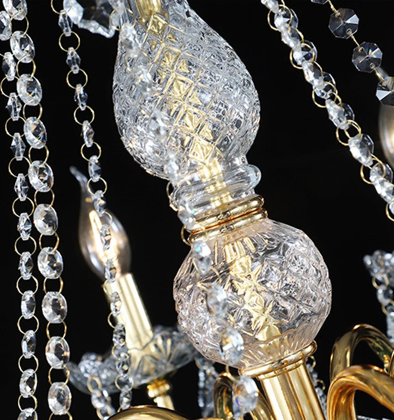Detailed view of central crystal column on golden chandelier with intricate cut glass and gold accents.