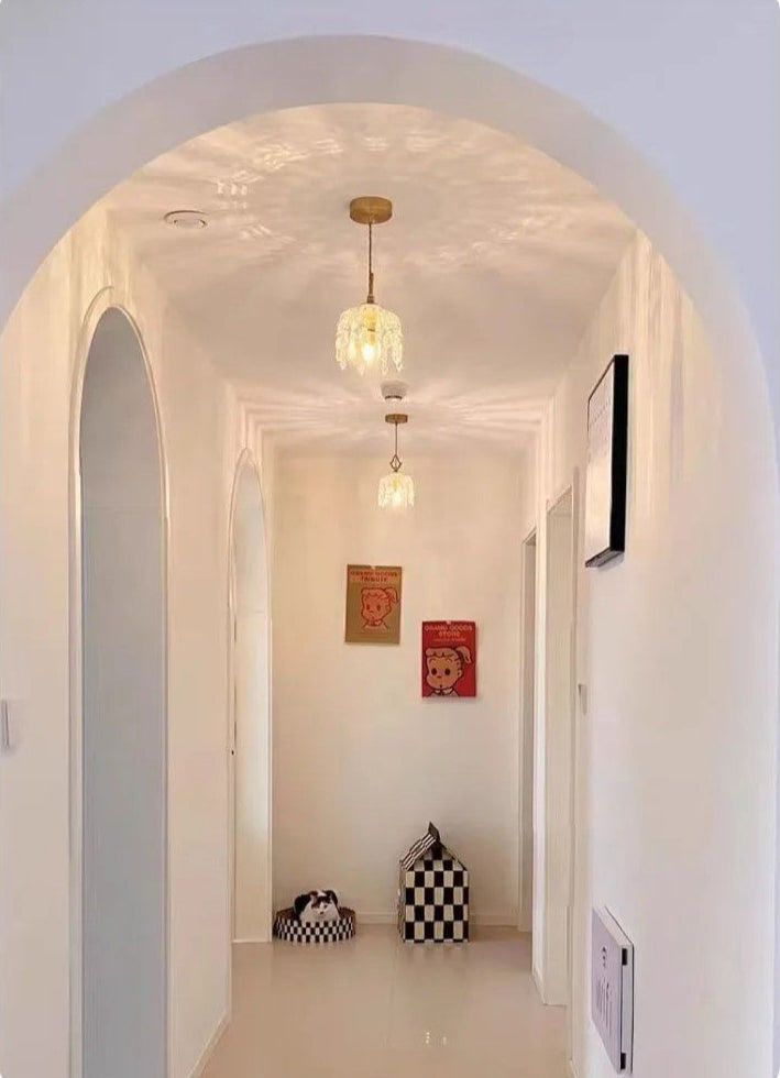 Hallway with French Vintage Crystal Chandeliers - Copper Hanging Lamps creating ambient reflections on white ceiling.
