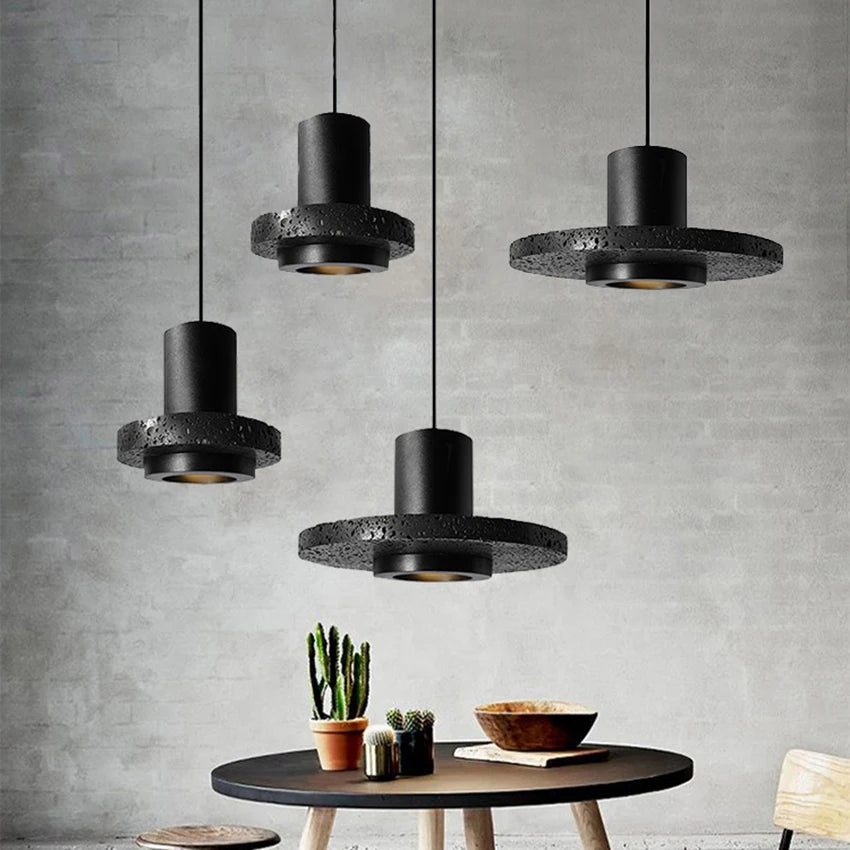 Industrial stone pendant lamp by LUXELY hanging above a modern dining table, perfect for small dining room lighting.