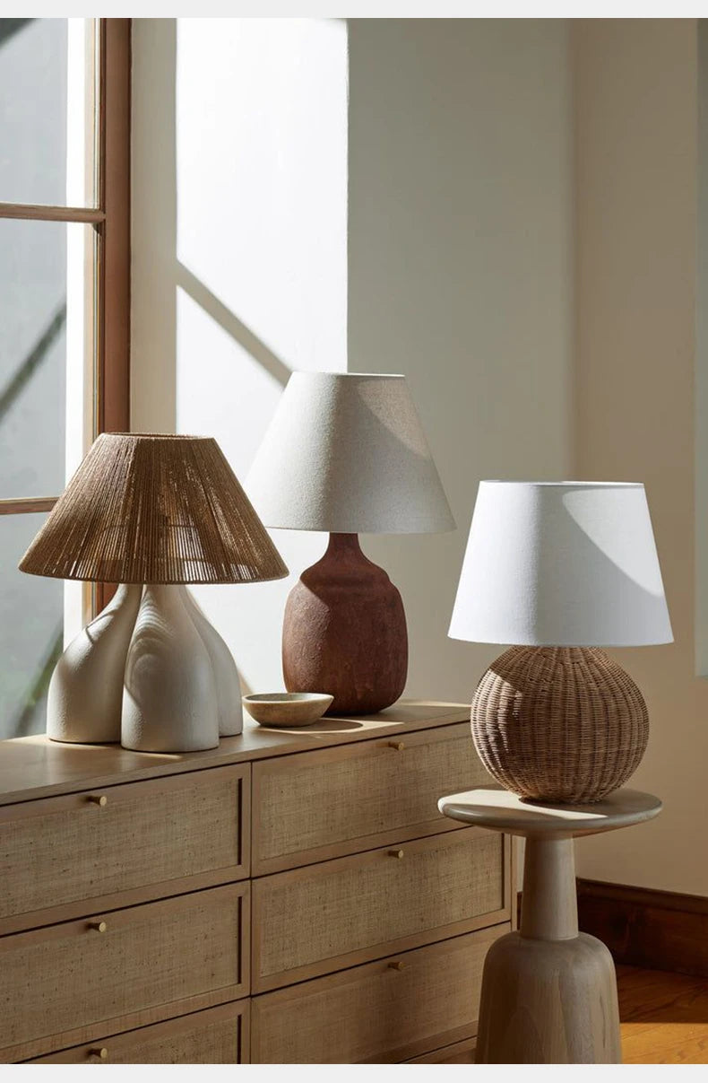 Wabi-sabi fabric wood table lamp displayed with other Japanese-style lamps on wooden furniture, enhancing natural bedroom aesthetics.