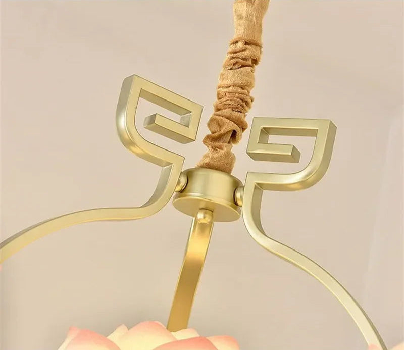 Detail of vintage lotus flower LED pendant light showing gold frame and fabric-wrapped cord for elegant ceiling decor.