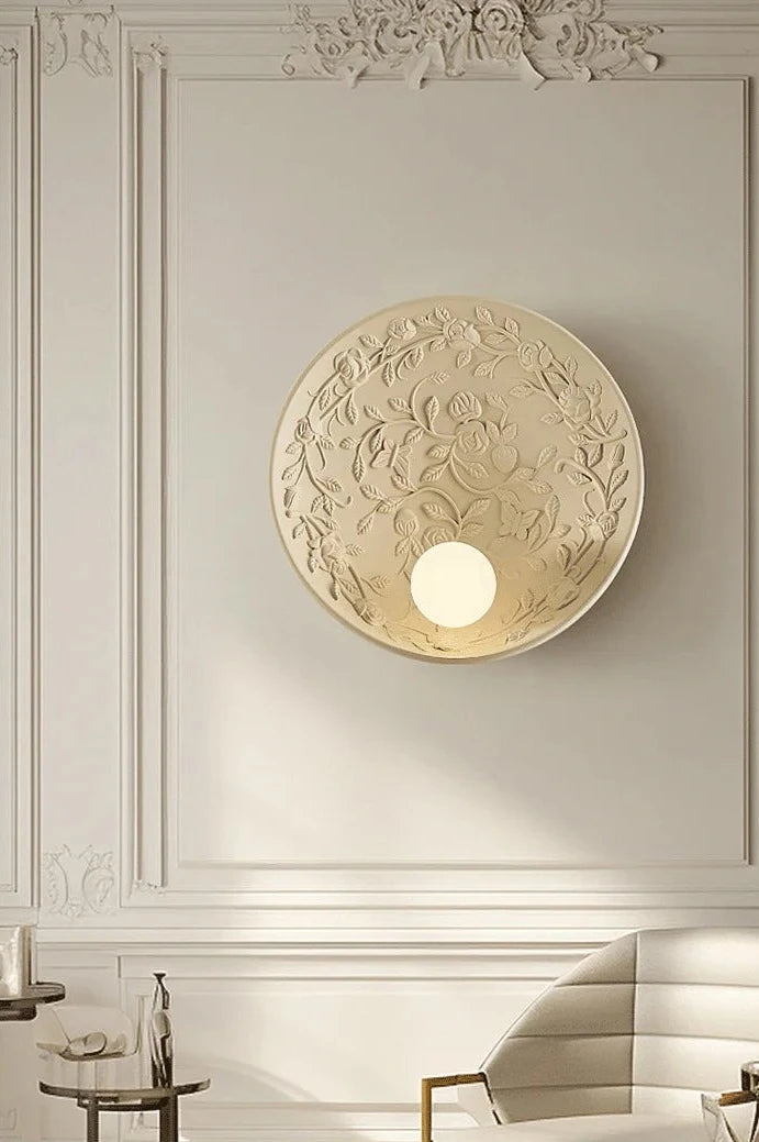 Vintage art deco wall lamp with rose carvings, mounted in elegant interior, perfect for upscale home or office decor.