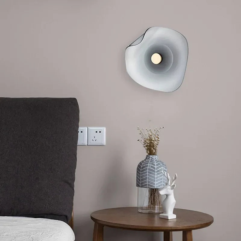 Glass modern wall lamp mounted in a bedroom setting, showcasing soft ambient lighting and contemporary art deco design.