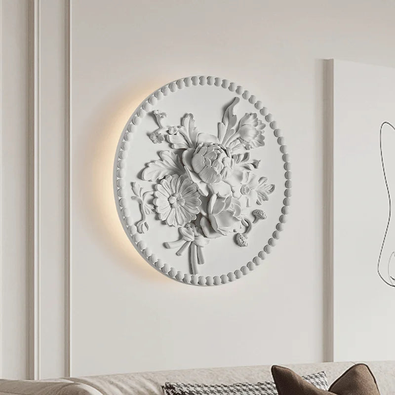 Mounted French vintage sconce with royal floral relief, casting ambient light in a modern living room setting for upscale decor.