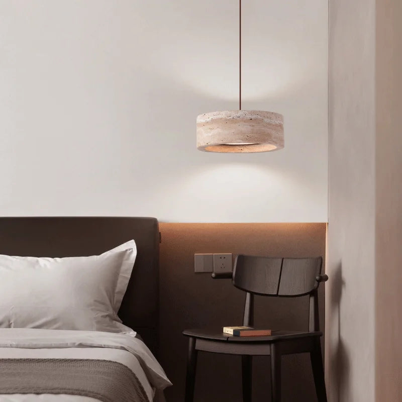 Travertine Retro Pendant Light above a bedside chair, showcasing its warm LED light and adjustable wire for versatile bedroom lighting.