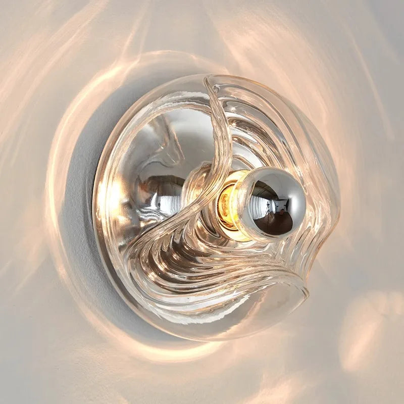 Close-up of designer LED glass wall lamp mounted on wall, showcasing elegant wave pattern and soft light diffusion.