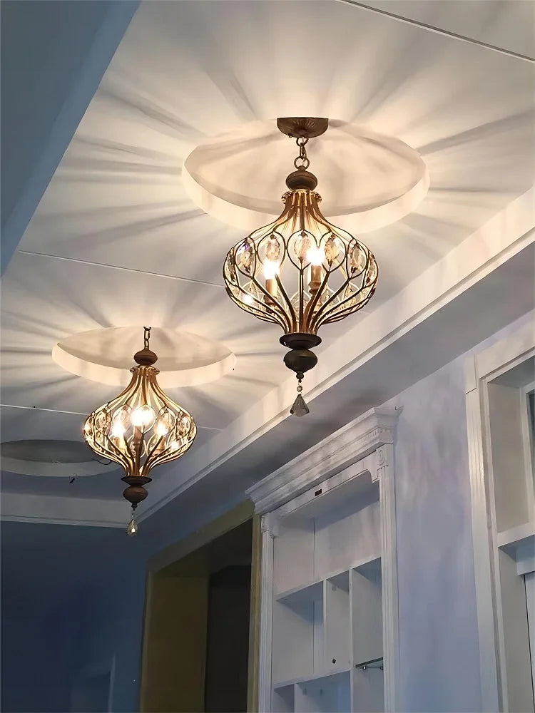 Pair of retro crystal lantern chandeliers installed on ceiling, casting decorative light patterns in a hallway or corridor.